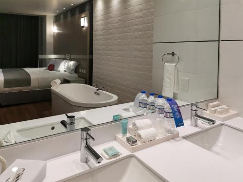 baño con lavabo y espejo grande en Ramada Encore by Wyndham Monterrey Apodaca Zona Aeropuerto, en Monterrey