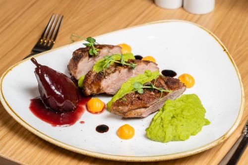 a plate of food with meat and vegetables on a table at Holiday Inn Bucharest - Times by IHG in Bucharest
