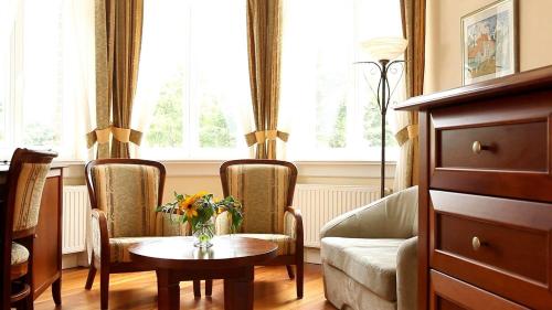 a living room with a table and two chairs and a couch at Villa Stella Maris in Międzyzdroje