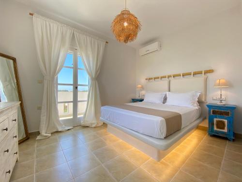 プラカにあるSeaside Naxos • Holiday Villasのベッドルーム1室(ベッド1台、大きな窓付)