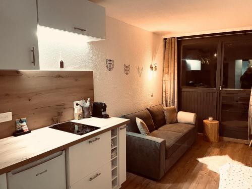 une cuisine et un salon avec un canapé et une table dans l'établissement Appartements à Chantemerle, à Saint-Chaffrey