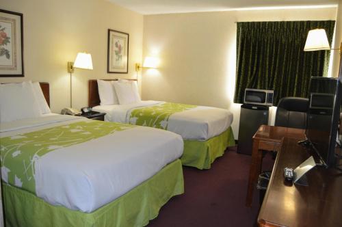 a hotel room with two beds and a television at Extended Stay Warrenton Inn in Warrenton