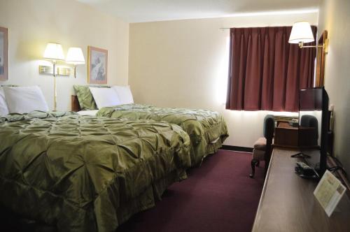a hotel room with two beds and a television at Extended Stay Warrenton Inn in Warrenton