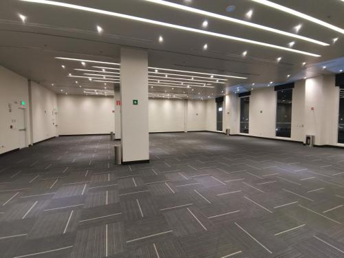 a large room with a wooden floor and white walls at Ramada Encore by Wyndham Monterrey Apodaca Zona Aeropuerto in Monterrey
