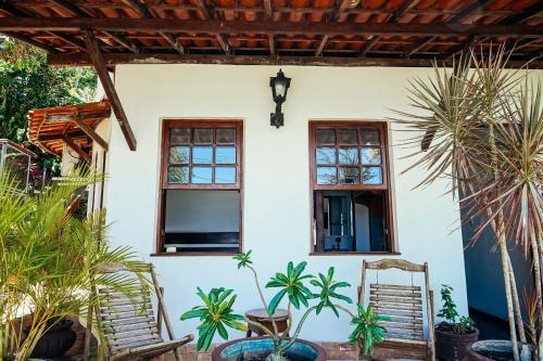 a white house with two windows and plants at Pousada Natureza in Morro de São Paulo