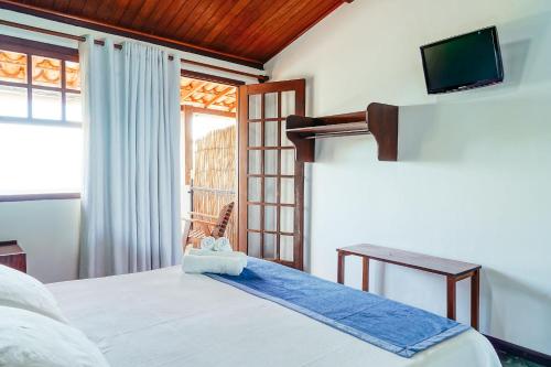 a bedroom with a bed and a tv on the wall at Pousada Natureza in Morro de São Paulo
