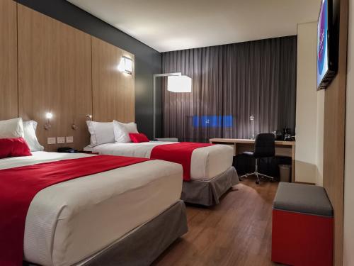 a hotel room with two beds and a desk at Ramada Encore by Wyndham Monterrey Apodaca Zona Aeropuerto in Monterrey