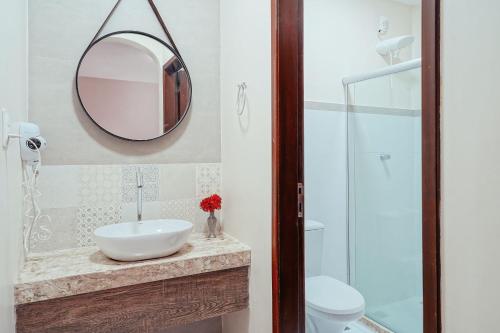 a bathroom with a sink and a mirror at Pousada Natureza in Morro de São Paulo