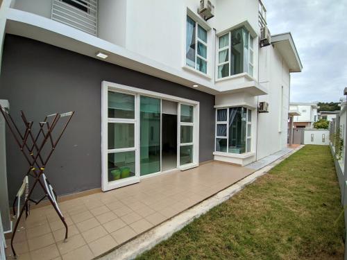 Cette grande maison blanche dispose d'une grande terrasse. dans l'établissement Hom Villa 5rm 12-22 pax Wifi Netflix BBQ SteamBoat Games Beach Water Park, à Kota Tinggi