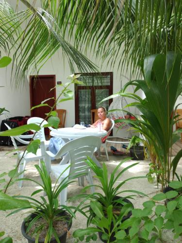 a man sitting in a chair at a table at Sunrise Inn in Thoddoo