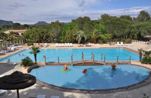a pool at a resort with a playground at Greenchalets Roquebrune Sur Argens in Roquebrune-sur-Argens