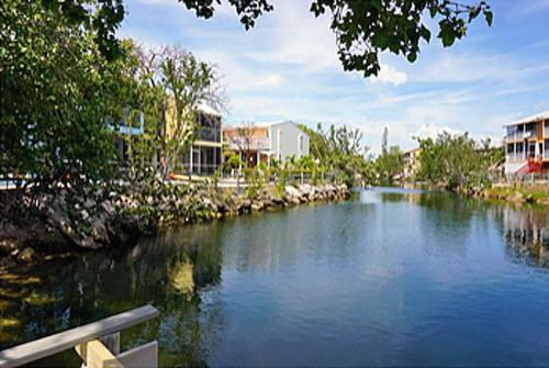 a river with a bench and buildings in the background at SEA MIST - Oceanfront-Lake-Kayak-Paddleboard-Bike in Key Largo