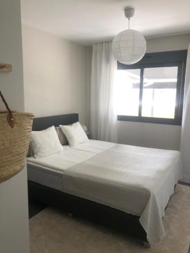 a bedroom with a large bed with a window at OASIS BEACH 7 - Apartment Lundgren in Torrevieja