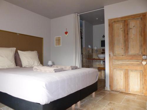 a bedroom with a bed and a wooden door at La fontaine de rocoule in Rochefort-en-Valdaine