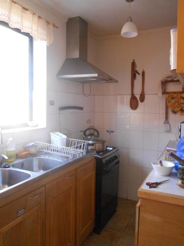 a kitchen with a sink and a stove at El Arbol Hostel in La Serena