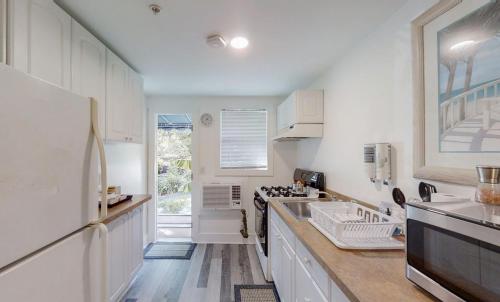 a white kitchen with a sink and a stove at Meranova Guest Inn in Dunedin
