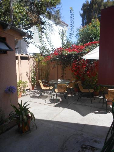 a patio with a table and chairs and flowers at El Arbol Hostel in La Serena