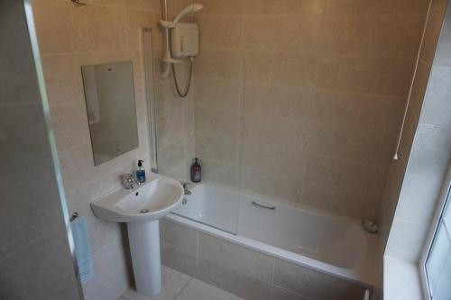 a bathroom with a sink and a bath tub and a sink at Meenadreen Cottage in Donegal