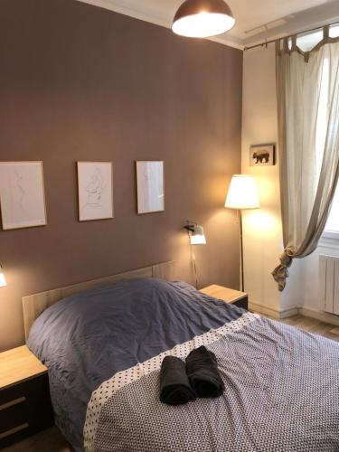 une chambre avec un lit avec des chaussures dessus dans l'établissement Magnifique Appartement 3 pièces Joliette Marseille PARKING PRIVATIF, à Marseille