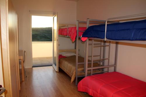 a room with three bunk beds and a doorway at Azores Youth Hostels - Santa Maria in Vila do Porto