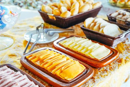 a table topped with containers of cheese and other pastries at Pousada Natureza in Morro de São Paulo