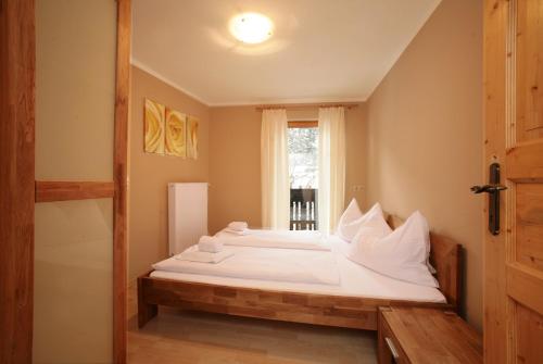 um quarto com uma cama com lençóis brancos e uma janela em Penthouse White Schmitten em Zell am See