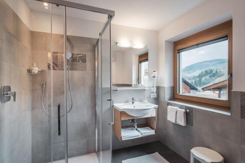 a bathroom with a sink and a shower at Garnì Iosc in San Vigilio Di Marebbe