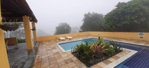 una casa con una piscina con dos perros sentados junto a ella en Flat condomínio paraíso serra negra en Bezerros