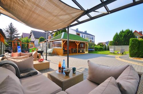 a patio with a couch and a gazebo at Plaża Apartament in Ustronie Morskie