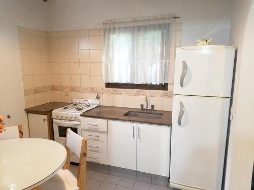 a kitchen with a white refrigerator and a table at Rosalia Suites in Loma Hermosa