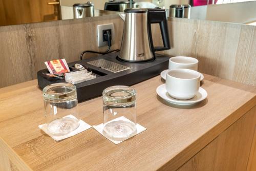 a counter with a coffee maker and glasses on it at Hotel Plaža Duće in Omiš