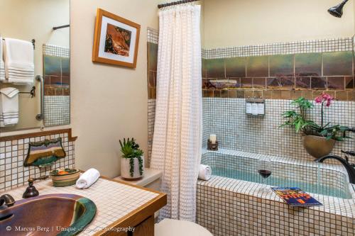 a bathroom with a tub and a sink and a shower at Adobe Rose Inn in Tucson