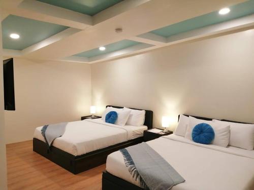 dwa łóżka w pokoju hotelowym z dwoma łóżkami w obiekcie R Bed and Breakfast w mieście Baguio