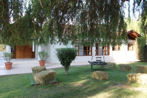 a house with hay bales in the front yard at De Los Andes Hotel Boutique in Ciudad Lujan de Cuyo