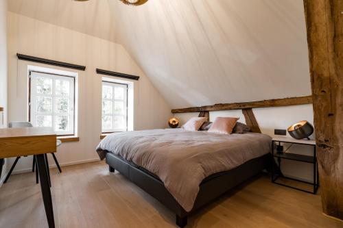 ein Schlafzimmer mit einem Bett und zwei Fenstern in der Unterkunft B&B Weselo in Mol