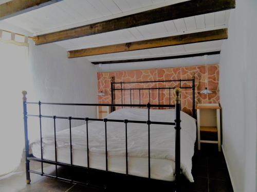 uma cama num quarto com uma parede de tijolos em Casita Blanca em El Perelló