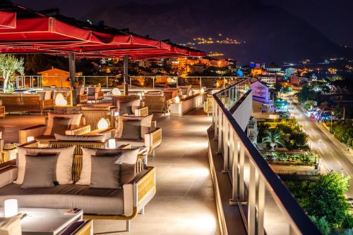 a rooftop bar with couches and a city at night at Hotel Plaža Duće in Duće