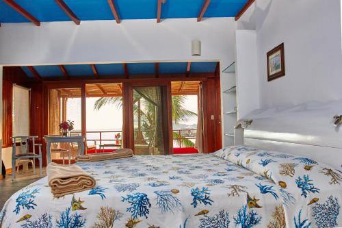 a bedroom with a large bed and a balcony at La Casa de Marita in Puerto Villamil