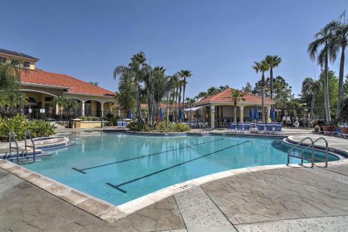 a swimming pool at a resort with palm trees at 8 Mi to Disney Villa with Screened Pool and Lanai in Kissimmee