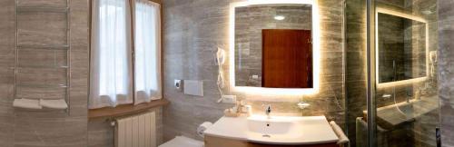 a bathroom with a sink and a mirror at Hotel Villa Fosine in Pinzolo