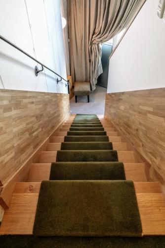 a staircase with green carpeted stairs and wooden floors at Mercure Poitiers Centre in Poitiers