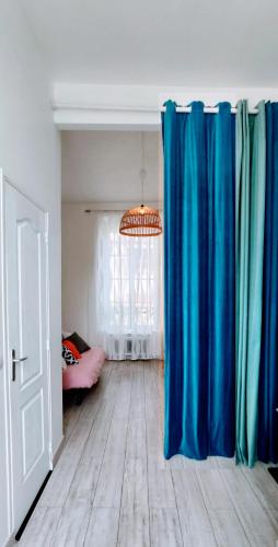 une chambre avec des rideaux bleus et une chambre avec un lit dans l'établissement Studio 3 étoiles lumineux et calme à 250 m de la plage, à Mers-les-Bains