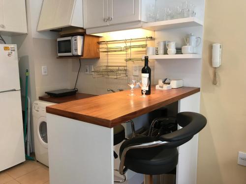 a kitchen with a counter with a bottle of wine at Monoambiente En Arturo Prat in Montevideo