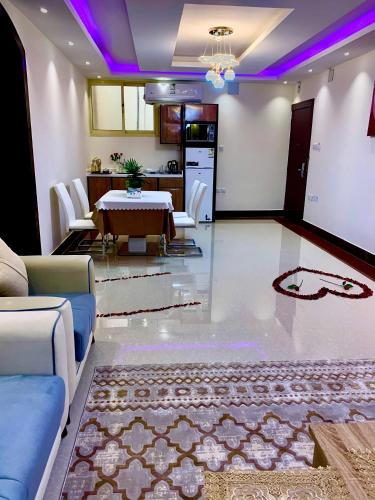 a dining room with a table and a kitchen with purple lighting at شقق حدائق الزيتون للوحدات السكنية -اقتصادية in Hail