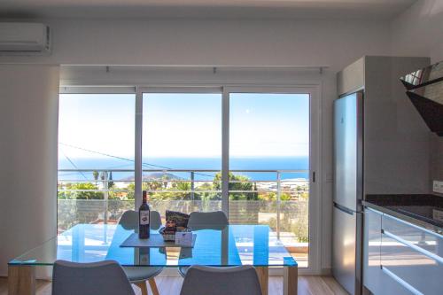 a dining room with a glass table and a view of the ocean at Apartamentos Dos Palmas in El Paso