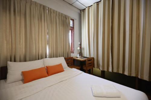 Ban Don Muang (1)にあるBanana Hostel Donmuangのベッドルーム1室(白いベッド1台、オレンジ色の枕2つ付)