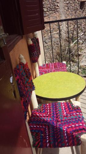 a table and two chairs on a balcony at Gîte Atlas Mazik in Imlil
