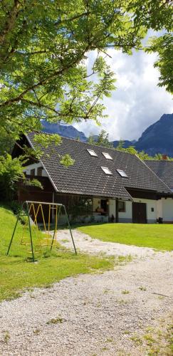 a playground in front of a building with a house at Apartment Sonce in Bohinj