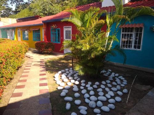 a palm tree in front of a colorful house at Villa San Nicolás in Melgar