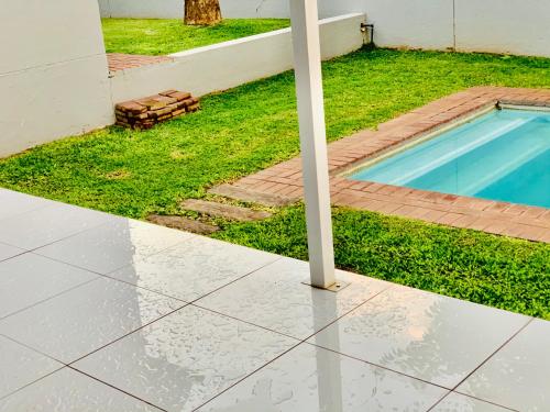 a pool with a pole next to a house at 774Ways Holiday Home in Hartbeespoort